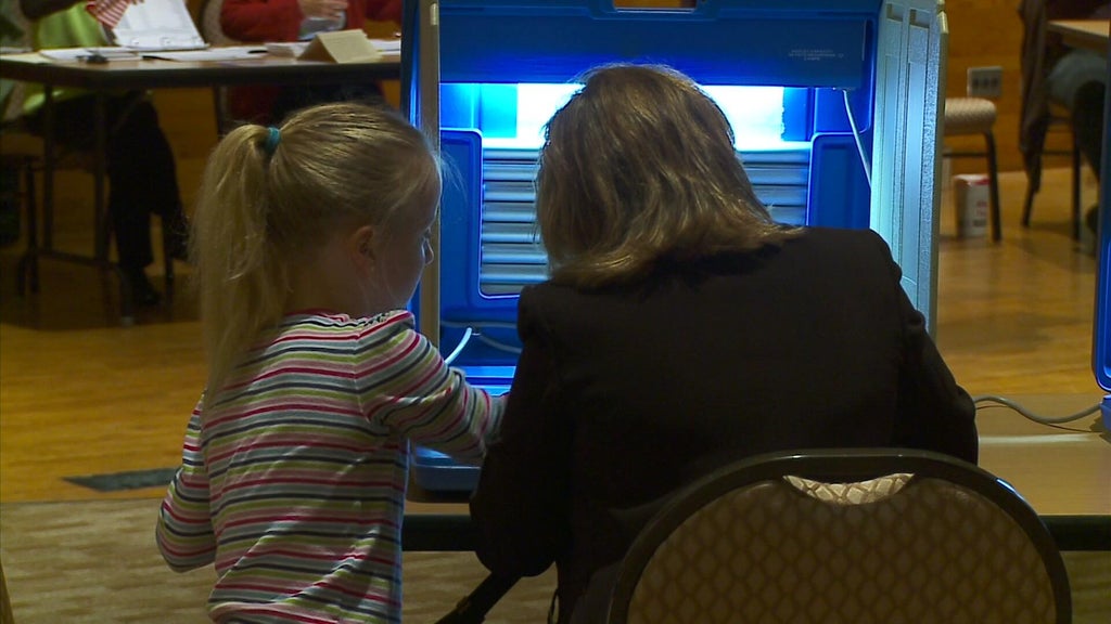 Minnesotans casting ballots, symbolizing high voter turnout and civic engagement.